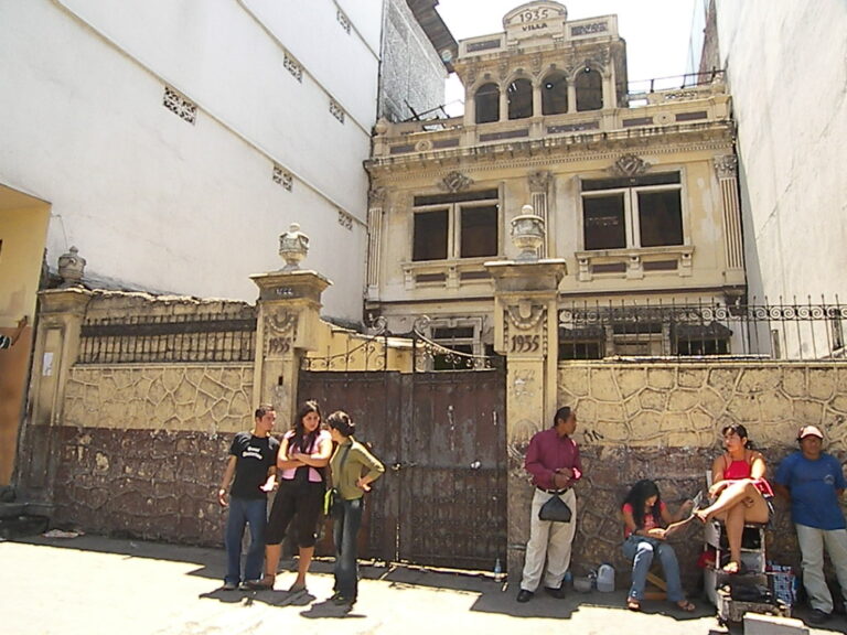 Primera visita a Villa Rosita, 2006. Frente a la casa en abandono, ubicada en la calle Colón, entre Quito y Pedro Moncayo, la artista María Lorena Peña Puga inició el registro que daría origen a casi dos décadas de obra dedicadas a rescatar su memoria. Foto cortesía.
