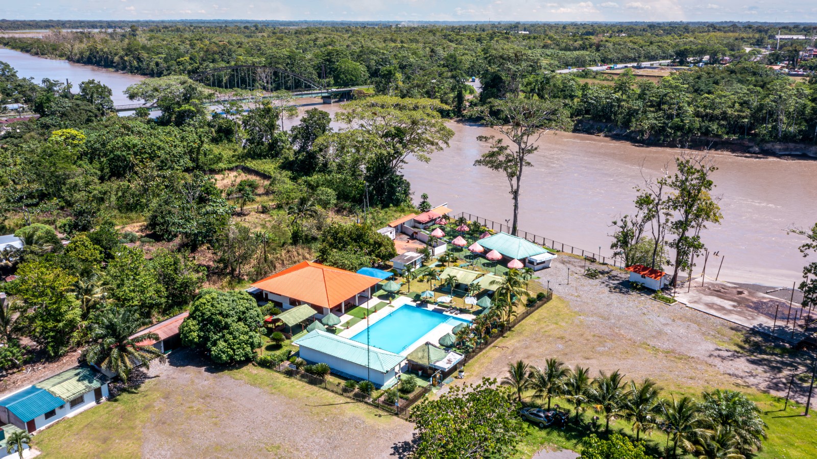 Vista aérea de un complejo turístico junto al río en La Joya de los Sachas, donde la naturaleza amazónica y la infraestructura local se combinan para recibir a los visitantes en un entorno de descanso y aventura. Foto cortesía