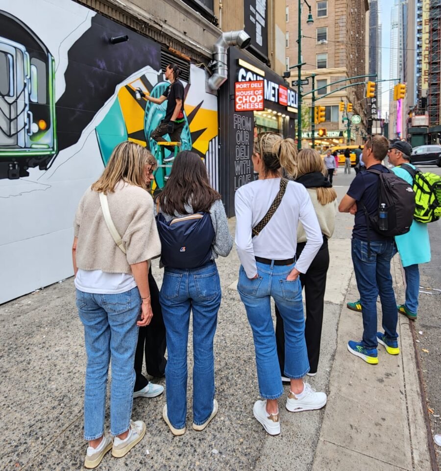 Visitantes observan una intervención artística en una calle de Manhattan. En Nueva York, turismo, comercio, arte y espacio público forman parte de una misma experiencia urbana. Foto: archivo personal de Olga Guerra.